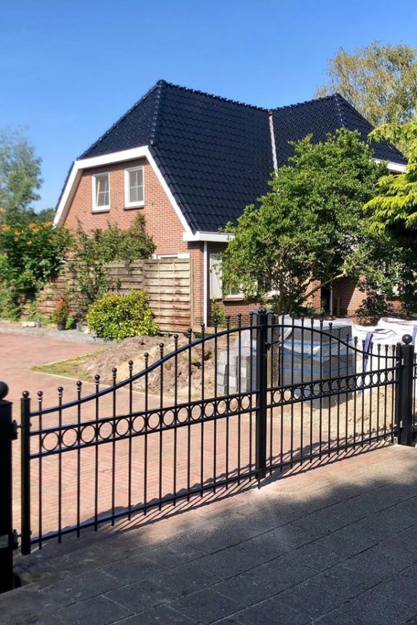 Vrijstaandhuis met een sierhekwerk en poort